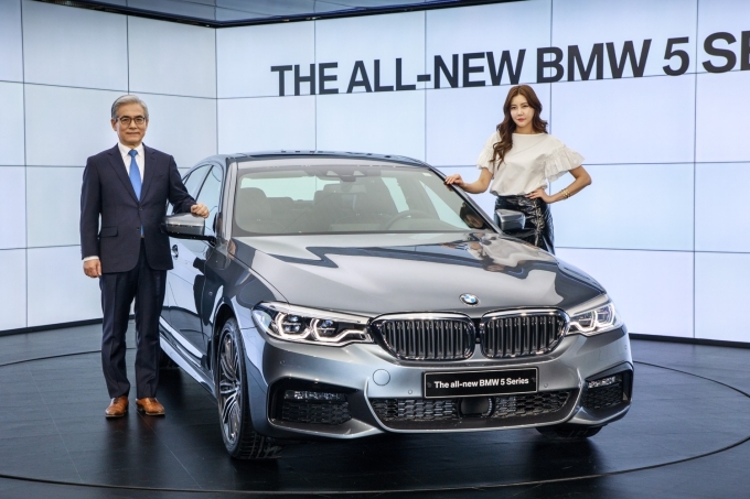 김효준 BMW 그룹 코리아 사장이 신형 5시리즈 출시행사에서 도우미와 함께 포즈를 취하고 있다.