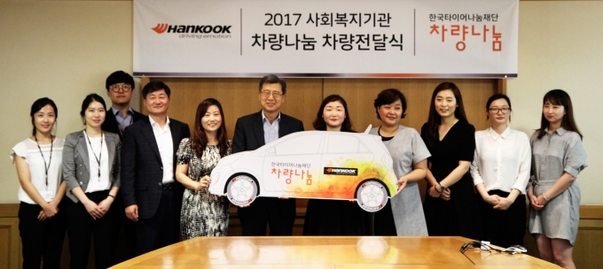 한국타이어 대표이사 서승화 부회장(왼쪽에서 여섯 번째)이 ‘2017 사회복지기관 차량나눔’ 차량 기증식에 참여한 사회복지기관 관계자들과 함께 행사 기념촬영을 진행하고 있다.