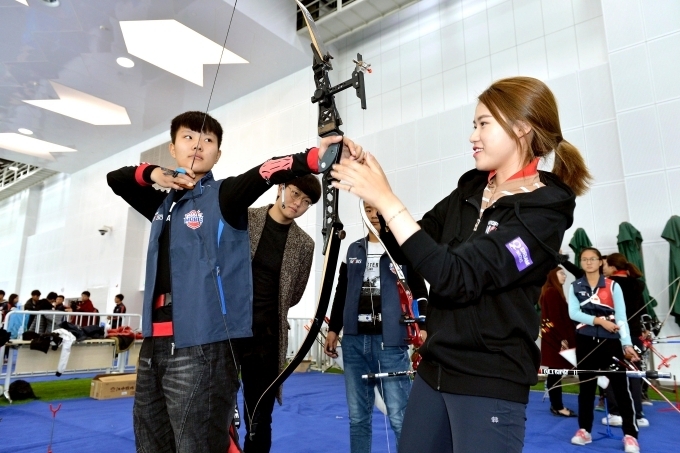 지난 8일 중국 텐진 양궁사격훈련장에서 열린 ‘어린이 양궁교실’에 참가한 중국 어린이가 현대모비스 양궁단 소속 심예지 선수의 지도를 받으며 활시위를 당기고 있다.