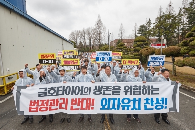 금호타이어 일반직 직원들이 "법정관리 반대 및 외자유치 찬성" 구호를 외치며 광주공장 내부를 행진하고 있다.