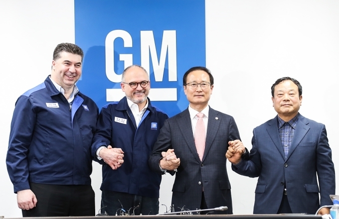 (사진 왼쪽부터) 한국지엠 카허 카젬 사장, GM 해외사업부문 배리 엥글 사장, 더불어민주당 홍영표 의원, 한국지엠 협력업체 비상대책위원장 문승 대표가 손을 맞잡고 포즈를 취하는 모습.