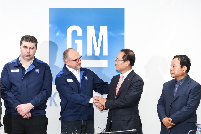 GM 해외사업부문 배리 엥글 사장과 더불어민주당 홍영표 의원이 악수를 하고 있는 모습.