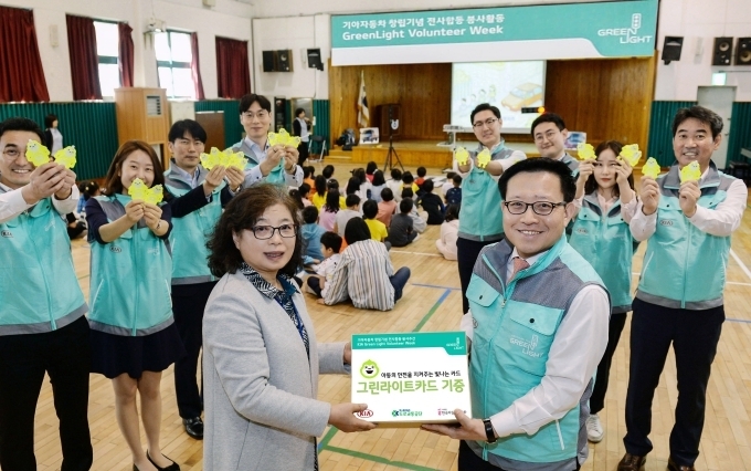곽용선 기아차 경영전략실장(오른쪽)과 강경옥 반원초등학교 교감선생님(왼쪽)이 ‘그린 라이트 카드’ 전달을 기념해 포즈를 취하고 있는 모습.
