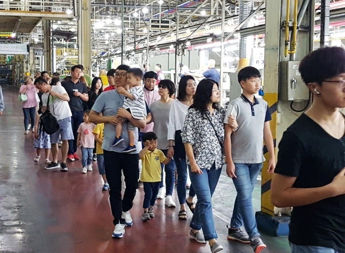 참가자들이 렉스턴 브랜드 모델들이 만들어지는 평택공장 생산라인을 견학하고 있다.