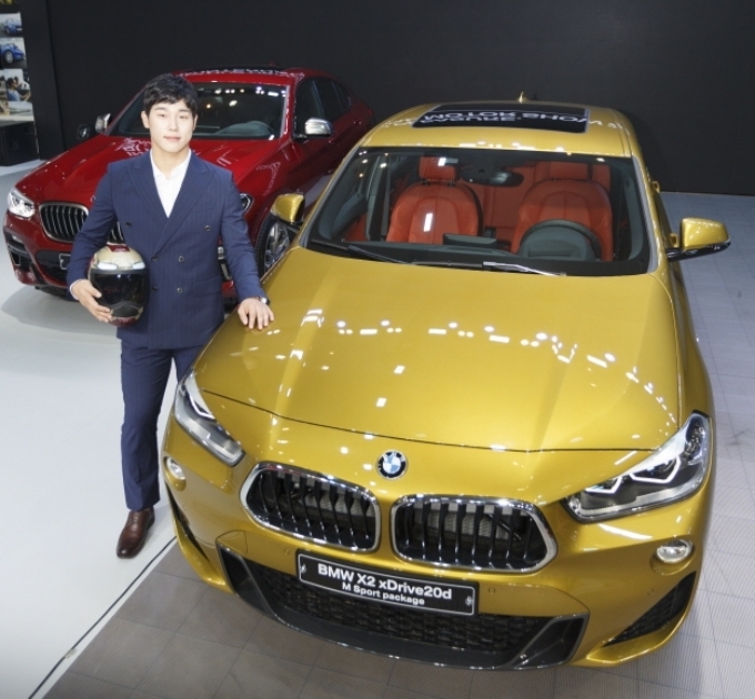 스켈레톤 국가대표 윤성빈 선수가 BMW 뉴 X2 옆에서 포즈를 취하고 있다.