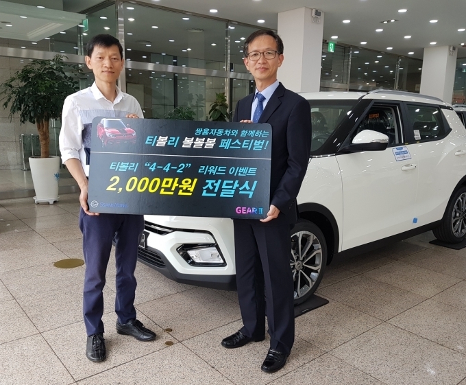 쌍용자동차 박세홍 경인지역본부장(오른쪽)이 2천만원 페이백 행운의 주인공이 된 권영욱씨(52세, 경기 부천)에게 경품을 전달하고 있다.