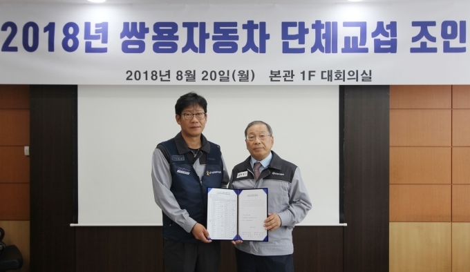 쌍용자동차 최종식 대표이사(사진 오른쪽)와 홍봉석 노동조합위원장이 임단협 합의안에 서명 후 기념촬영을 하고 있다.