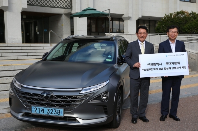 18일 인천광역시청에서 진행된 ‘현대자동차–인천광역시 수소전기차 보급 활성화 상호협력 MOU 체결식’에서 이원희 현대자동차 대표이사 사장(오른쪽)과 박남춘 인천광역시장(왼쪽)이 현대자동차의 수소전기차 ‘넥쏘’ 앞에서 기념 촬영을 하고 있는 모습