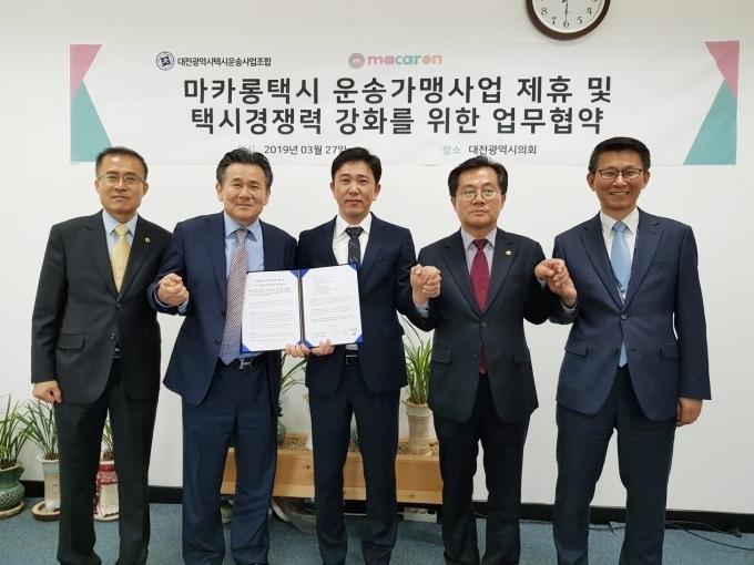 27일 대전광역시의회에서 대전 지역에 혁신형 택시 브랜드 ‘마카롱택시’ 도입을 위한 업무협약을 맺고 기념촬영을 했다. (왼쪽부터) 이종호 대전광역시의회 복지환경위원장, 김성태 대전광역시택시운송사업조합 이사장, 이행열 KST모빌리티 대표, 이광복 대전광역시의회 산업건설위원장, 박제화 대전광역시 교통건설국장.