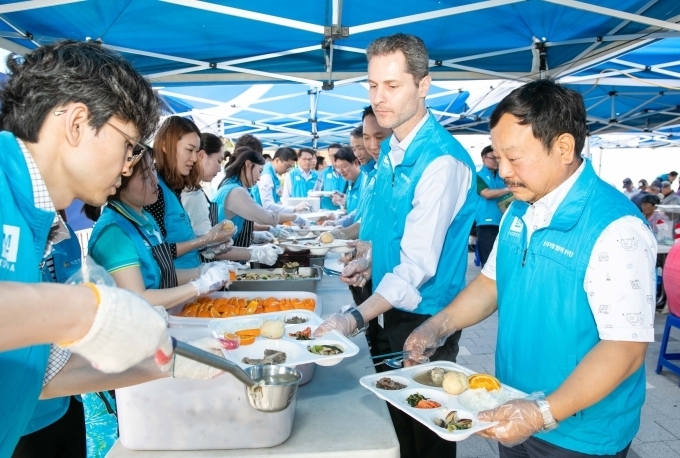 독거노인을 대상으로 무료 급식 봉사를 하고 있는 마르시오 루콘 한국지엠 구매부문 부사장과 문승 한국지엠 협신회 회장