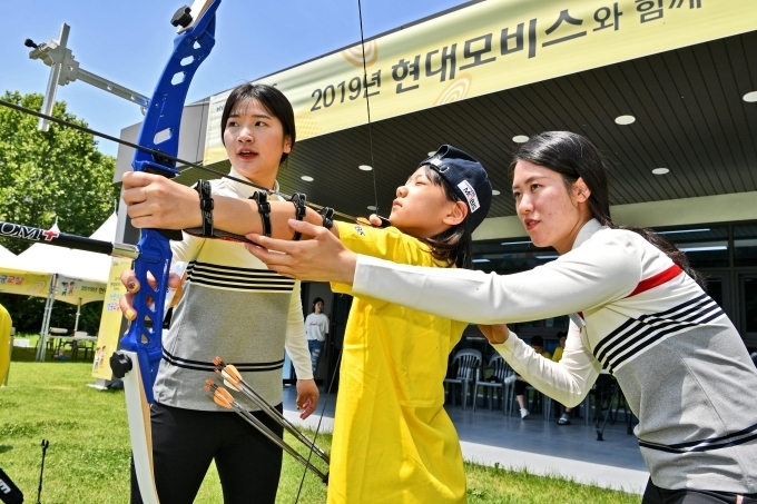 최근 열린 네덜란드 세계선수권에서 우승한 강채영 선수(좌)와 컴파운드 국가대표 소채원(우) 선수가 초등학생을 지도하고 있다. 