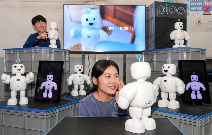 관람객들이 스타트업 서큘러스가 개발한 휴머노이드형 반려 로봇 파이보와 소통하고 있다.