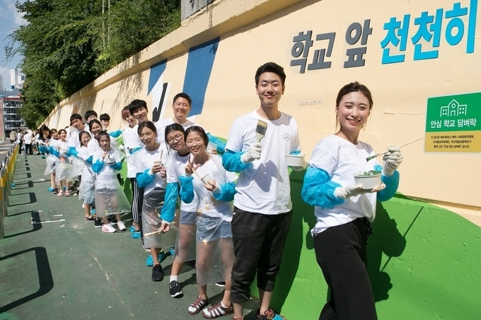 부산 해운대구 재송초등학교에서 안전한 통학로 조성을 위해 ‘메르세데스-벤츠와 함께하는 안심 학교 담벼락’ 벽화 그리기 봉사활동 모습