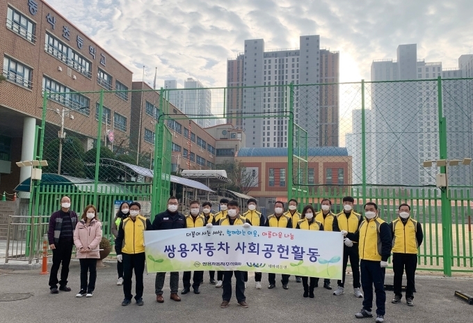 지난 19일 쌍용자동차 임직원들이 평택 동삭초등학교에서 교통안전 캠페인을 실시한 뒤 기념촬영을 하고 있다.