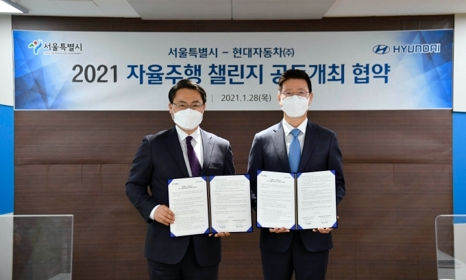 28일 서울시 서소문청사에서 진행된 ‘현대차그룹-서울시, 2021자율주행 챌린지 공동개최 업무협약(MOU)’ 체결식에서 기념 촬영을 하고 있는 모습. (왼쪽부터) 서울시 황보연 도시교통실장, 현대차그룹 연구개발기획조정담당 박동일 부사장.