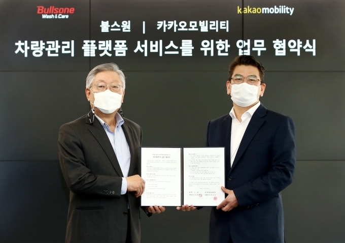 불스원 이창훈 대표(좌)와 카카오모빌리티 안규진 부사장(우)이 차량 관리 플랫폼 서비스를 위한 업무협약식에서 기념촬영을 하고 있다.