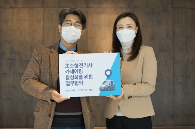 박진희 쏘카 사업본부장(오른쪽)과 김종빈 더함 이사가 24일 서울 중구 페이지 명동(구 한국YWCA연합회관)에서 열린 ‘초소형 전기차 카셰어링 서비스 제공’ 업무 협약식에서 기념 촬영을 하고 있다.
