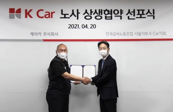 정인국 케이카 사장(오른쪽)과 구자균 케이카 지회장(왼쪽)이 지난 20일 노사 상생을 위한 협약식을 갖고 기념촬영을 하고 있다.