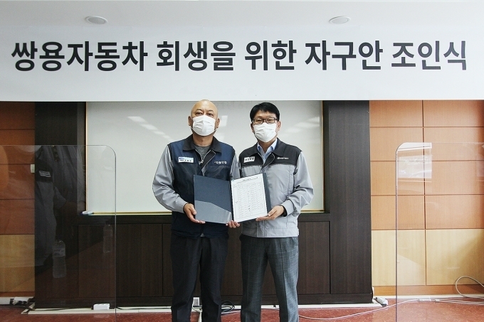 쌍용자동차는 14일 평택공장에서 노사 대표가 참석한 가운데 회사 회생을 위한 조인식을 가졌다. 정용원 관리인(사진 오른쪽)과 정일권 노동조합 위원장이 합의안에 서명한 후 기념촬영을 하고 있다.