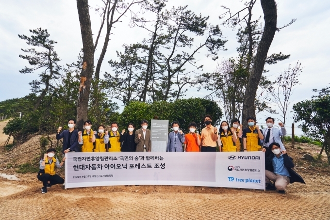 (중앙 현판 왼쪽) 현대차 CSV전략팀 최원준 팀장, (중앙 현판 오른쪽) 국립자연휴양림관리소 이영록 소장, 트리플래닛 임직원 등 주요 관계자들과 신시도 초등학교 학생 및 교사들이 기념 사진을 촬영하는 모습.