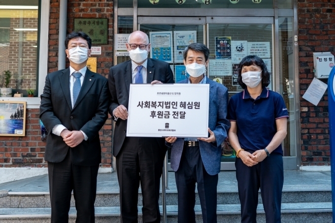 용산스포츠 오토모빌의 프랭크 슈타인라이트너 대표(좌측에서 두 번째)가 혜심원 권필환 원장(우측에서 두 번째)에게 후원금을 전달했다.