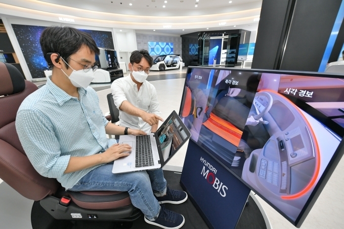 현대모비스가 세계 최초로 개발한 뇌파 측정 기반 운전자 모니터링 시스템, ‘엠브레인’을 개발한 연구원들이 관련 기술을 시험하는 모습.
