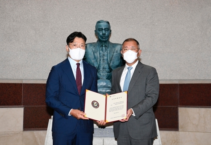 현대차그룹 정의선 회장(사진 우측)이 기부금 약정서에 서명한 뒤 고려중앙학원 김재호 이사장과 기념 사진을 촬영하고 있다.