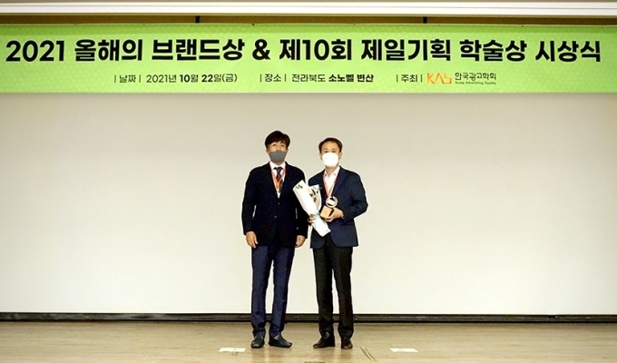 이강승 금호타이어 G.마케팅 담당 상무(오른쪽)와 안대천 한국광고학회 회장(왼쪽)이 지난 22일에 열린 2021 올해의 브랜드상 시상식에 참석해 기념촬영을 하고 있다.