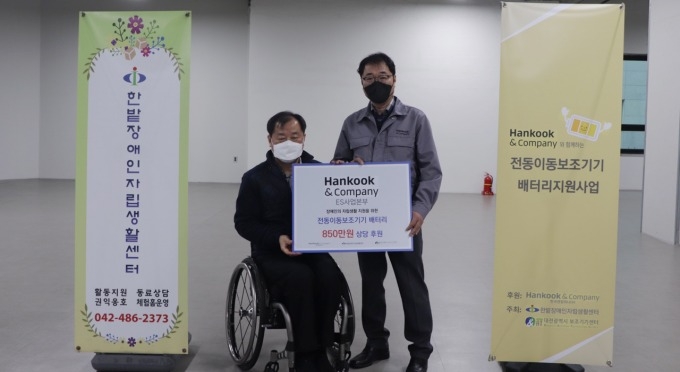 지난 8일 한국앤컴퍼니 ES)생산부문장 윤종달 상무(오른쪽)와 한밭장애인자립생활센터 남인수 소장(왼쪽)이 전동이동보조기기 배터리 나눔 전달식에서 기념 촬영을 하고 있다.