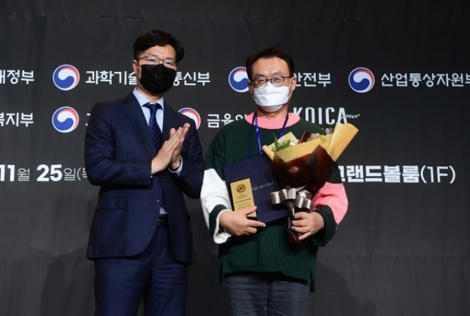 (왼쪽부터) 구혁채 과학기술정보통신부 대변인과 강동식 현대오토에버 상무가 CSR 필름페스티벌에서 기념 촬영을 하고 있다