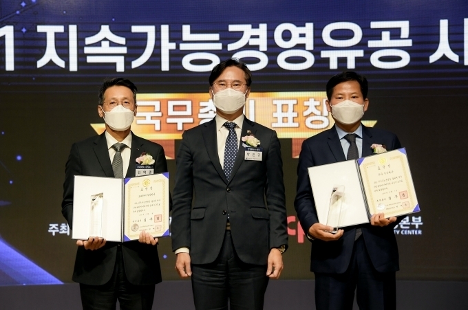 기아 김상대 기업전략실장(전무, 오른쪽)이 ‘2021 지속가능경영유공 정부포상’ 국무총리 표창을 수상하고 산업통상자원부 박진규 차관(가운데)과 기념 촬영하고 있다.