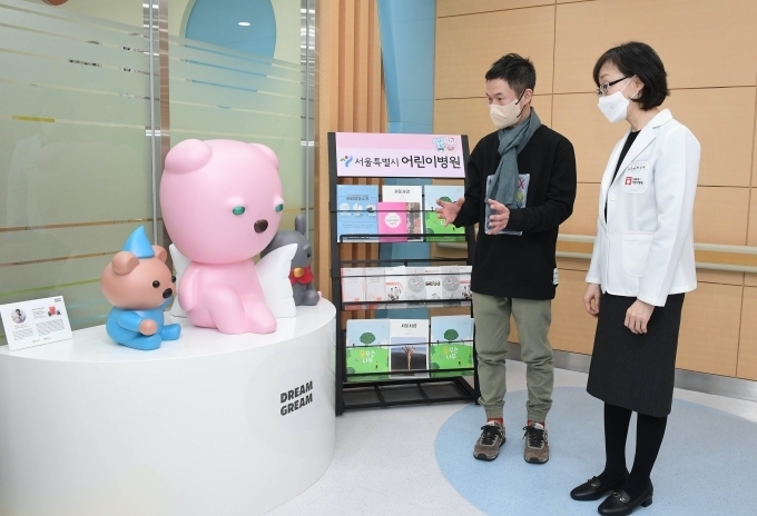 최진숙 서울특별시 어린이병원장(오른쪽)과 노준 작가(왼쪽)가 함께 병원 2층 치과병동 앞에 설치된 드림그림의 작품을 살펴보고 있다.