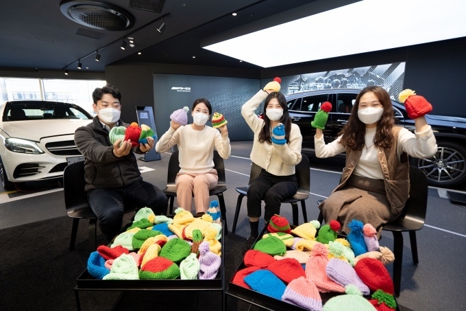 서초동 한성자동차 본사에서 임직원들이 ‘신생아살리기 레드로드’ 캠페인을 통해 직접 만든 모자와 함께 기념 촬영을 하고 있다.