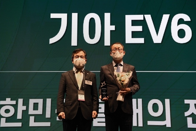 17일 xEV 트렌드 코리아 2022 개막식 행사에서 기아 판매사업부장 이한응 전무(오른쪽)가 환경부 홍정기 차관으로부터 EV 어워즈 환경부 장관상 ‘올해의 전기차’를 수상하는 모습