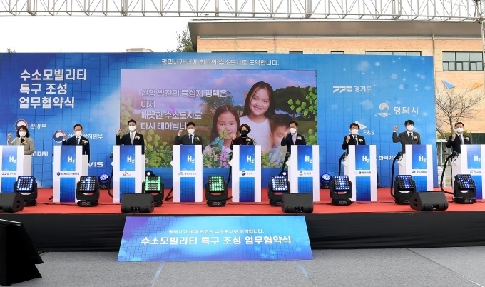 (왼쪽부터)경기도 엄진섭 환경국장, 한국가스기술공사 조용돈 사장, SK E&S 추형욱 사장, 홍기원 국회의원, 환경부 한정애 장관, 평택시 정장선 시장, 홍선의 시의장, 현대차 정원대 국내지원사업부장, 현대글로비스 김현중 물류사업본부장이 체결식을 하고 있는 모습