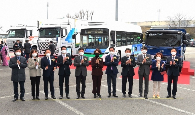 현대차 정원대 국내지원사업부장(오른쪽 세번째)과 체결식에 참석한 관계자들이 수소 상용차 앞에서 기념촬영을 하고 있는 모습