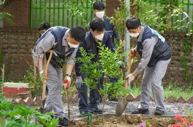 GM 한국 사업장 직원들이 갈산복지관 주변에 나무를 심는 자원봉사 활동 모습