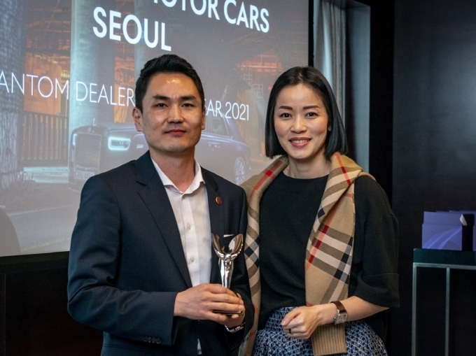 2021 팬텀 올해의 딜러 & 최우수 통합 마케팅 캠페인 상을 수상한 롤스로이스모터카 서울의 김지웅 팀장(왼쪽)이 롤스로이스모터카 아시아 태평양 지역 총괄 아이린 니케인(오른쪽)과 포즈를 취하고 있다.