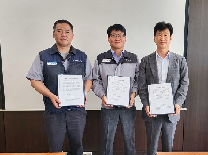 (왼쪽부터) 쌍용자동차 선목래 노조위원장, 쌍용자동차 정용원 관리인, KG ETS 엄기민 대표가 쌍용자동차 M&A관련 3자 특별협약서를 들고 포즈를 취하고 있는 모습.