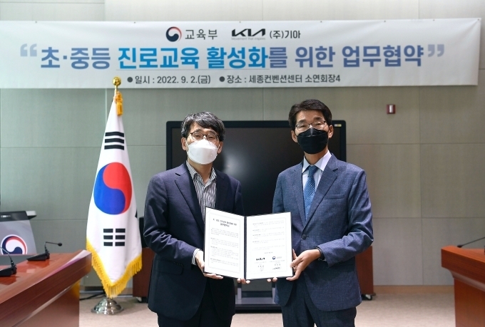 세종컨벤션센터에서 나주범 교육부 차관보(왼쪽), 권혁호 기아 국내사업본부장(오른쪽)이 업무협약을 체결하고 기념사진을 촬영하고 있는 모습