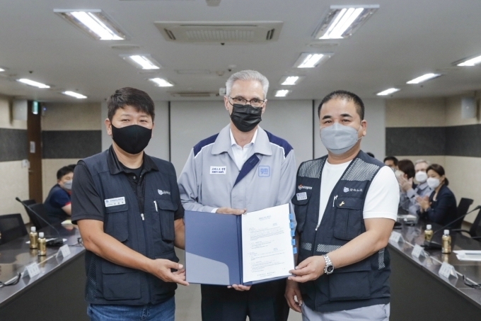 금속노조 한국지엠지부 김준오 지부장과 로베르토 렘펠 한국지엠 사장이 2년 연속 무분규 임단협 교섭을 기념하며 서로 악수를 하고있다.(좌측부터 금속노조 한국지엠지부 김준오 지부장, 로베르토 렘펠 한국지엠 사장)
