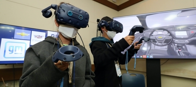 지난 28일 GM 다양성 주간 활동의 일환으로 개최된 직원 자녀 초청 이벤트에서 아이들이 VR 장비를 이용해 가상에서 자동차 내부를 관찰하고 있는 모습.