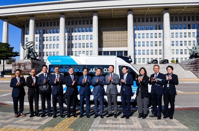 (왼쪽부터) 신승환 현대차 상무 - 오웅 국회사무처 관리국장 - 이청휴 현대차 전무 - 홍형선 국회사무처 사무차장 - 박장호 국회사무처 입법차장 - 공영운 현대차 사장 - 이광재 국회사무총장 - 장웅준 현대차 전무 - 김상수 국회사무처 기획조정실장 - 김수영 현대차 상무 - 김명진 국회사무처 방송국장 - 정환철 국회사무처 공보기획관이 국회 자율주행 셔틀 서비스에 투입될 현대차 '로보셔틀' 앞에서 기념사진을 촬영하고 있다.