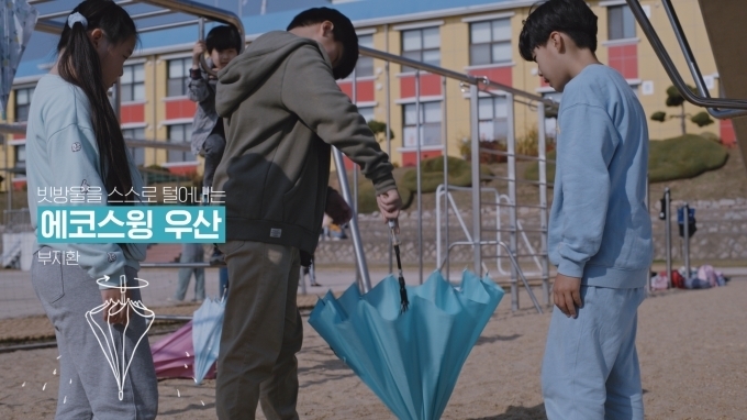 부지환(12, 대신초) 학생이 친구들 앞에서 본인이 발명한 에코스윙 우산 작동을 시연하는 모습. 에코스윙 우산은 우산대를 누르면 자동으로 돌아가서 빗방울을 스스로 떨어내기 때문에 우산을 감싸는 비닐이 필요 없는 친환경 우산이다.