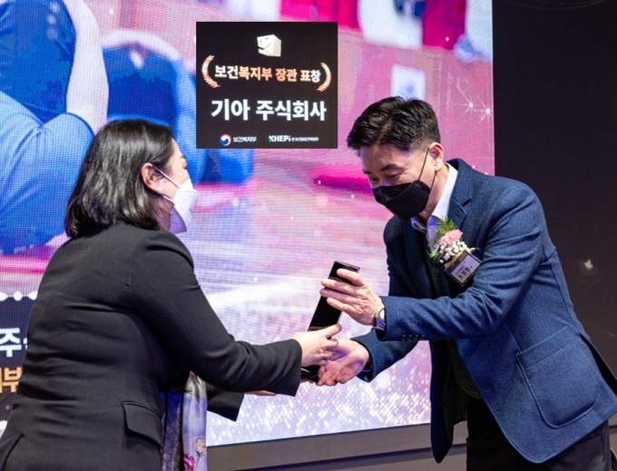 지난 21일 서울 강남구 보코서울강남에서 열린 '2022 건강친화기업 인증제도 성과대회'에서 진영주 보건복지부 건강정책국장(왼쪽)이 조정현 기아 안전환경센터장(오른쪽)에게 보건복지부장관 표창을 수여하는 모습.