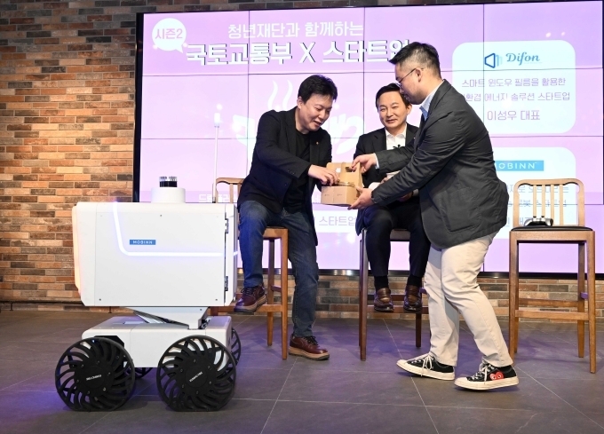 현대차그룹에서 분사한 스타트업 ‘모빈’의 자율주행 로봇(사진 왼쪽)이 원희룡 국토부 장관(오른쪽 둘째)을 비롯한 무대 참석자에게 커피를 전달하고 있다. 원 장관 왼쪽은 디폰 이성우 대표, 오른쪽은 모빈 최진 대표.