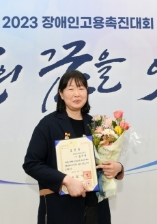 한국동그라미파트너스 김미영 사원이 시상식에서 기념촬영을 하고 있다.