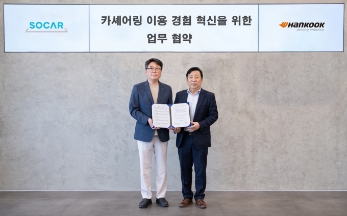 한국타이어 한)PC/LT영업담당 이용관 상무(우측)와 쏘카 MX(Mobility Experience) 김신명 본부장(좌측)이 체결식에서 기념촬영을 하고 있다.