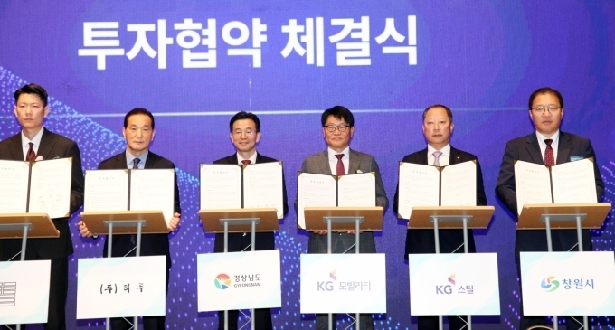 KG 모빌리티 정용원 대표이사(사진 오른쪽 세번째)과 KG 스틸 박성희 대표이사(사진 오른쪽 두번째), 경상남도 김병규 경제부지사(사진 왼쪽 세번째), 창원시 장금용 제1부시장(사진 오른쪽 첫번째)이 투자협약서를 보이고 있다.