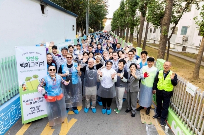 지난 30일, 인천시 부평구에 위치한 청천 2동 어린이집 일대 벽화 그리기 활동에 참여한 GM 한국 연구개발법인 브라이언 맥머레이 사장(앞쪽 왼편), 한국조지메이슨대학 로버트 매츠(Robert Matz) 대표(브라이언 사장 오른편)를 비롯해 전체 참석자들의 모습.